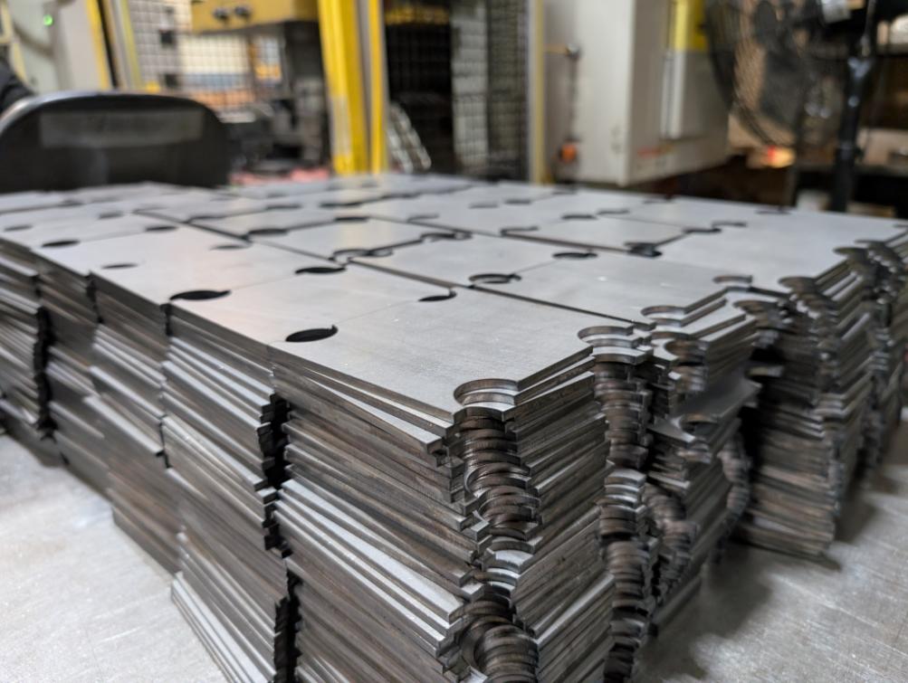 Laser-cut metal parts waiting for bending at Fox Valley Stamping, ready for the next step in the fabrication process.